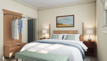 A cozy bedroom with a bed, two bedside tables, a bench at the foot of the bed, a dresser, hanging clothes, and a painting above the bed.